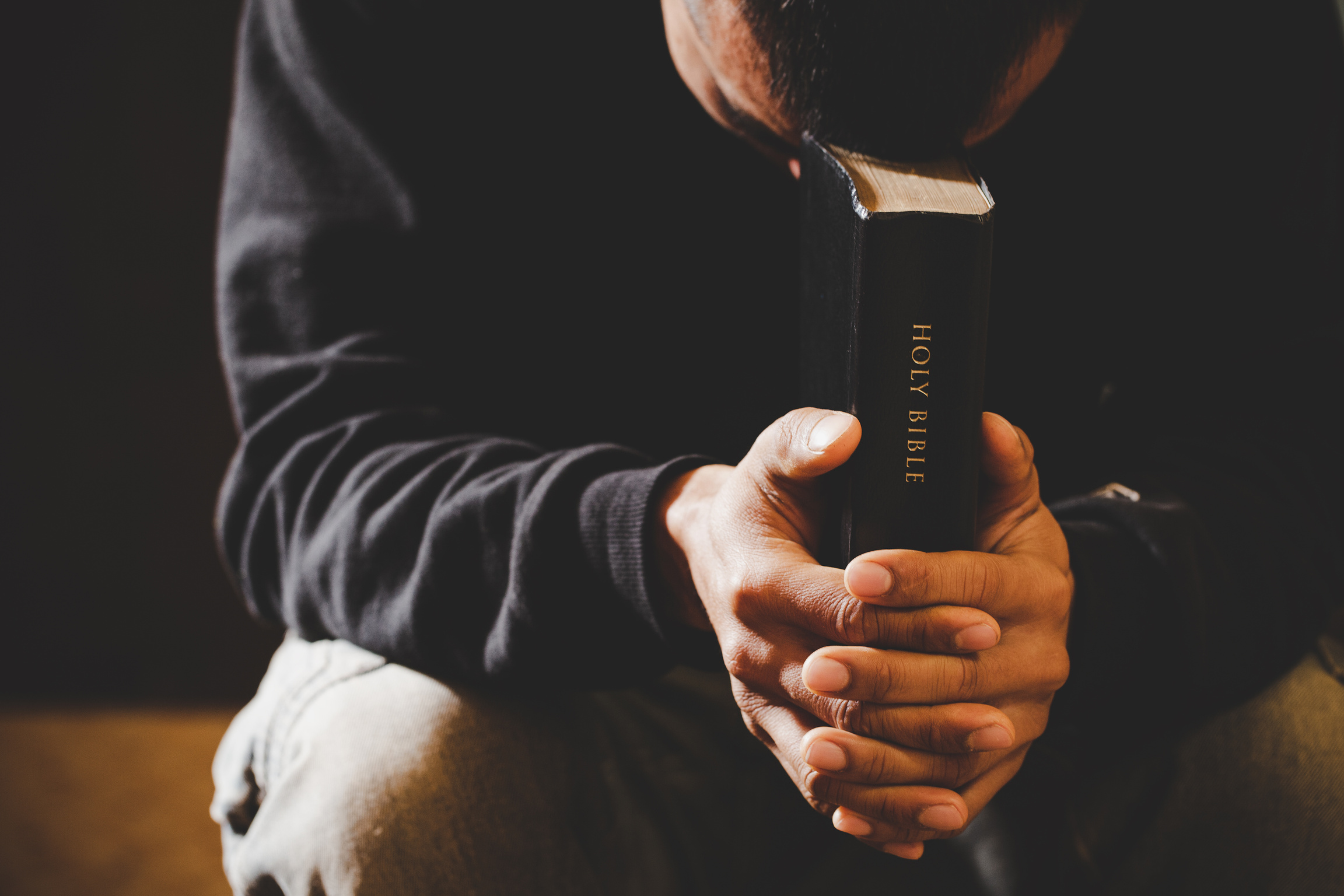 Man Holding a Bible and Praying